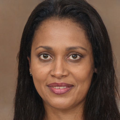 Joyful black adult female with long  brown hair and brown eyes