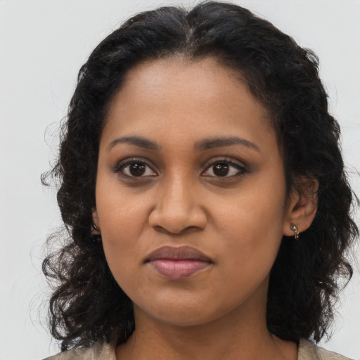 Joyful black young-adult female with long  brown hair and brown eyes