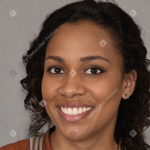 Joyful black young-adult female with long  brown hair and brown eyes