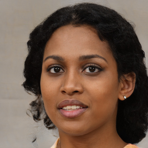 Joyful black young-adult female with medium  black hair and brown eyes