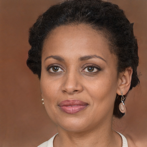 Joyful black adult female with long  brown hair and brown eyes