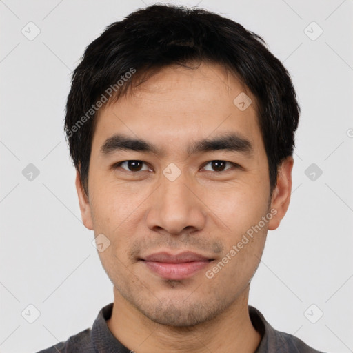 Joyful asian young-adult male with short  black hair and brown eyes