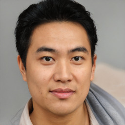 Joyful asian young-adult male with short  black hair and brown eyes