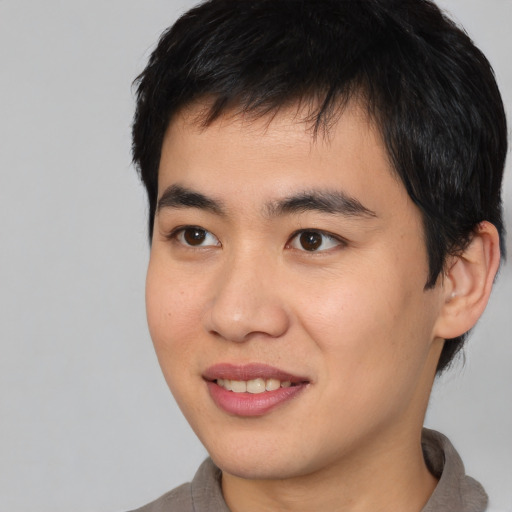Joyful asian young-adult male with short  black hair and brown eyes