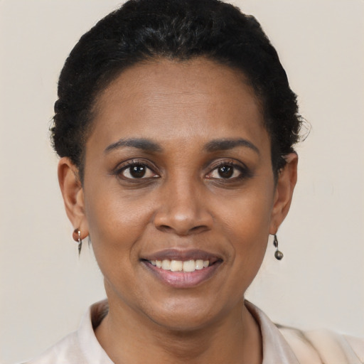 Joyful black young-adult female with short  black hair and brown eyes