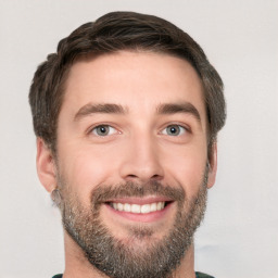 Joyful white young-adult male with short  brown hair and grey eyes