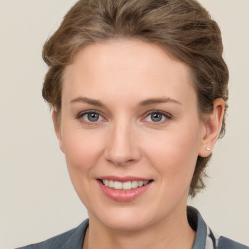 Joyful white young-adult female with short  brown hair and grey eyes