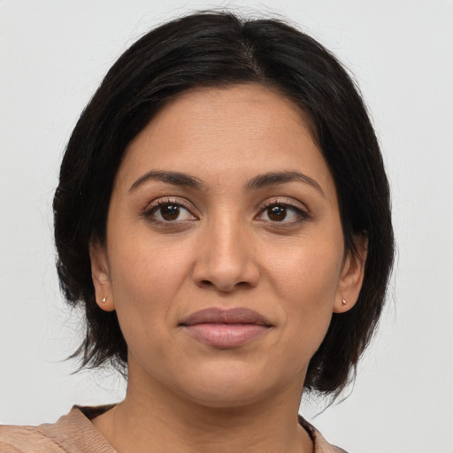 Joyful latino young-adult female with medium  brown hair and brown eyes