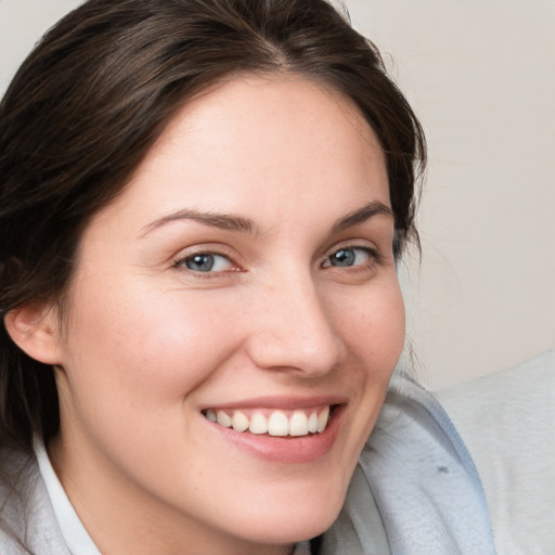 Joyful white young-adult female with medium  brown hair and blue eyes