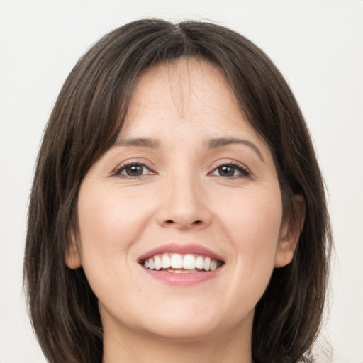 Joyful white young-adult female with long  brown hair and grey eyes