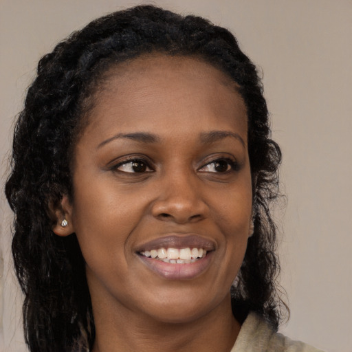 Joyful black young-adult female with long  black hair and brown eyes