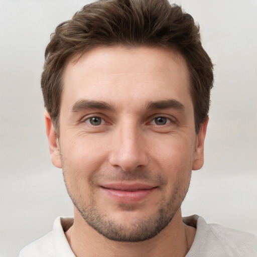 Joyful white young-adult male with short  brown hair and grey eyes