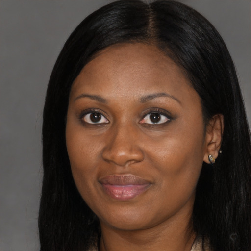 Joyful black young-adult female with long  black hair and brown eyes