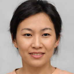 Joyful asian young-adult female with medium  brown hair and brown eyes