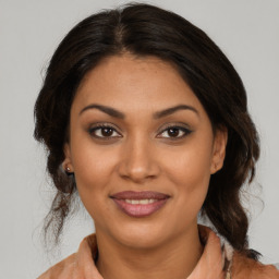 Joyful latino young-adult female with medium  brown hair and brown eyes