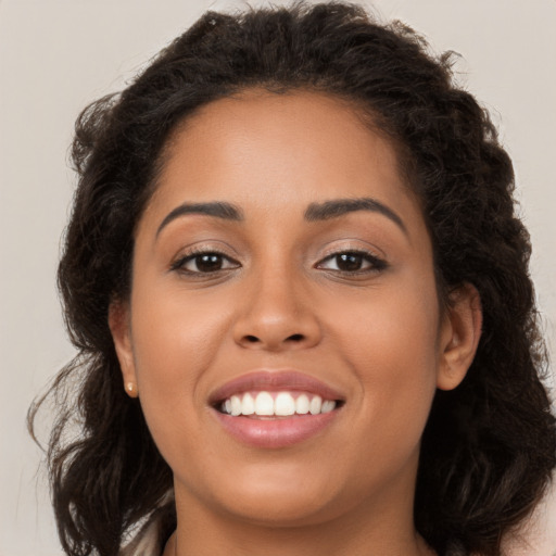 Joyful latino young-adult female with long  brown hair and brown eyes