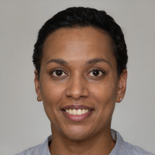 Joyful black adult female with short  black hair and brown eyes