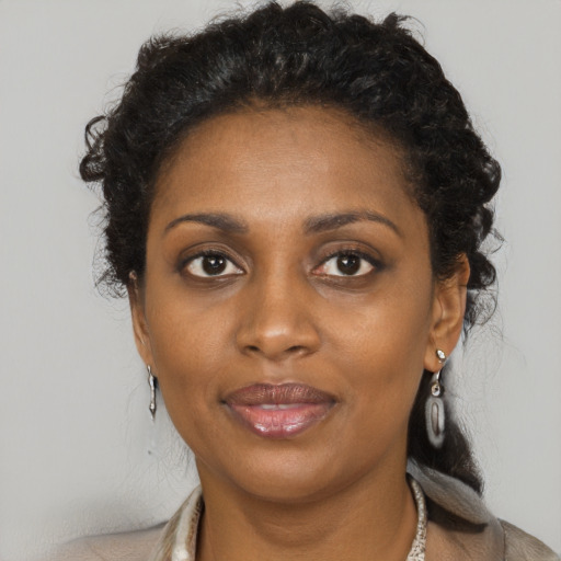 Joyful black adult female with long  brown hair and brown eyes