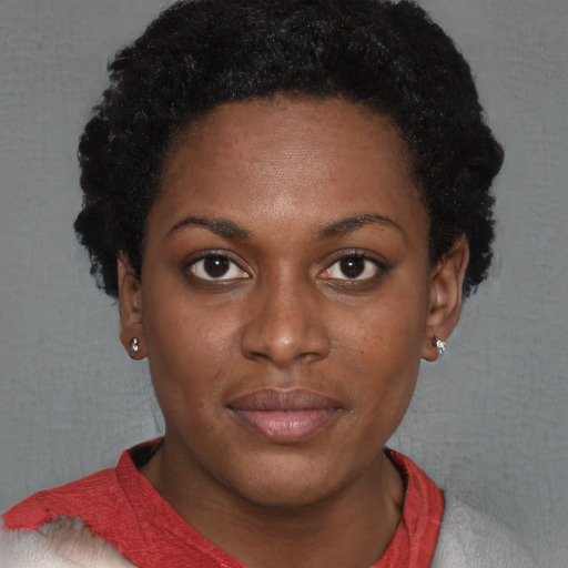 Joyful black young-adult female with short  brown hair and brown eyes