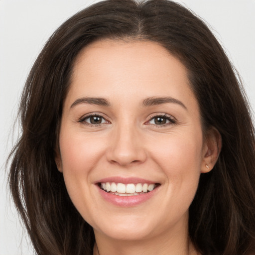 Joyful white young-adult female with long  brown hair and brown eyes