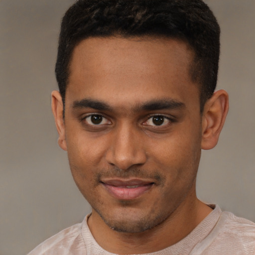 Joyful black young-adult male with short  brown hair and brown eyes