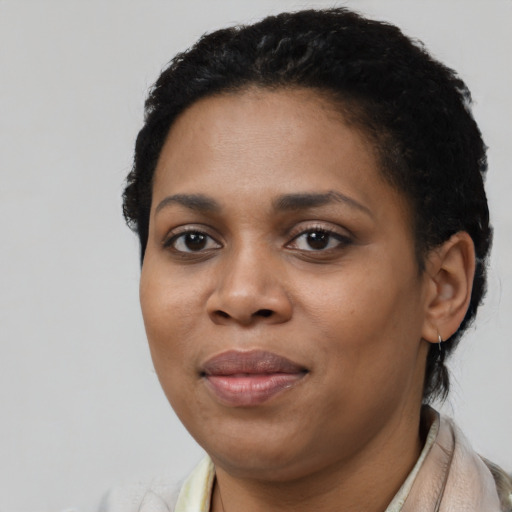 Joyful black young-adult female with short  black hair and brown eyes