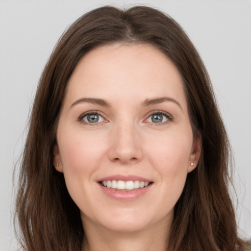 Joyful white young-adult female with long  brown hair and grey eyes