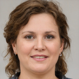 Joyful white adult female with medium  brown hair and grey eyes