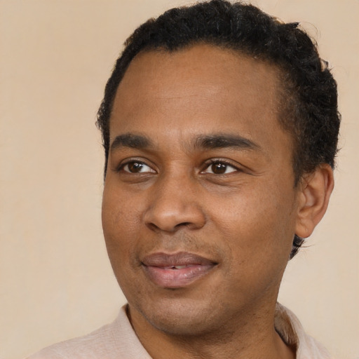 Joyful black young-adult male with short  brown hair and brown eyes