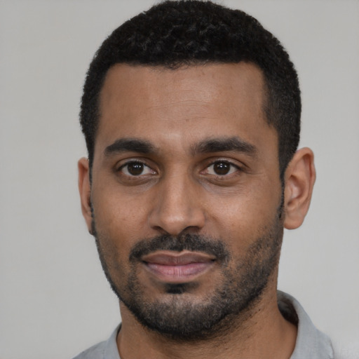 Joyful black young-adult male with short  black hair and brown eyes