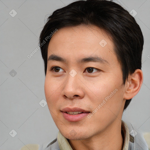 Joyful asian young-adult male with short  brown hair and brown eyes