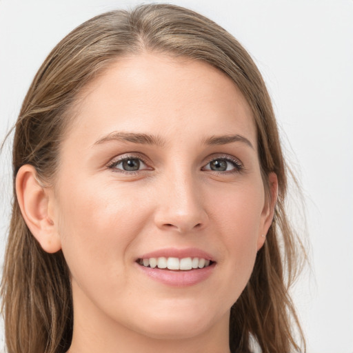 Joyful white young-adult female with long  brown hair and blue eyes