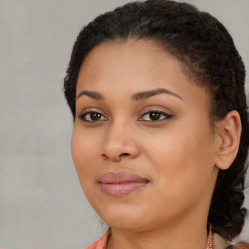Joyful black young-adult female with long  brown hair and brown eyes