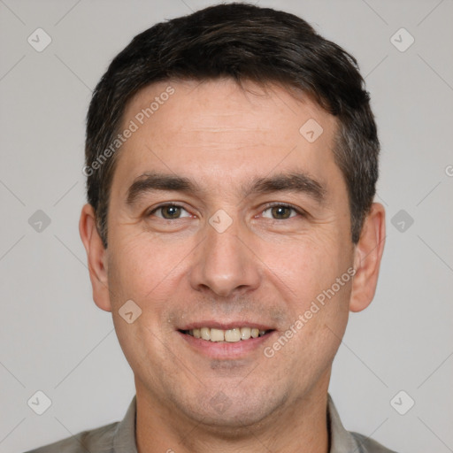 Joyful white adult male with short  black hair and brown eyes