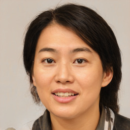 Joyful asian adult female with medium  brown hair and brown eyes