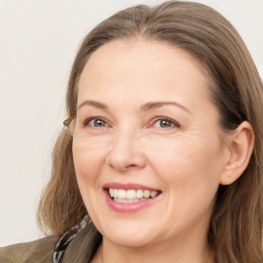 Joyful white adult female with long  brown hair and grey eyes