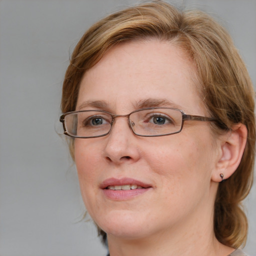 Joyful white adult female with medium  brown hair and blue eyes