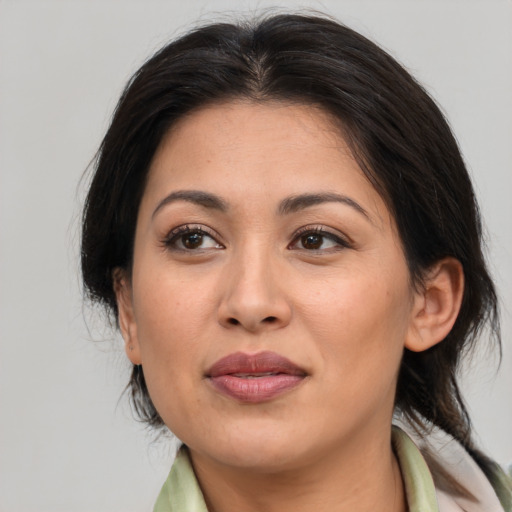 Joyful latino adult female with medium  brown hair and brown eyes