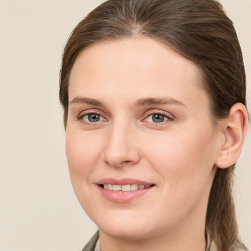 Joyful white young-adult female with medium  brown hair and grey eyes