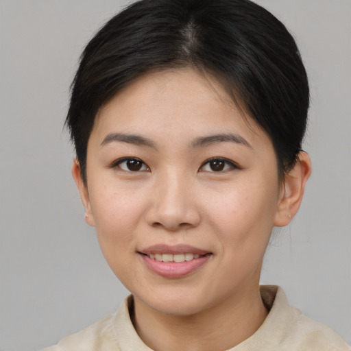 Joyful asian young-adult female with short  brown hair and brown eyes