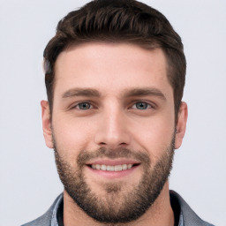 Joyful white young-adult male with short  brown hair and grey eyes