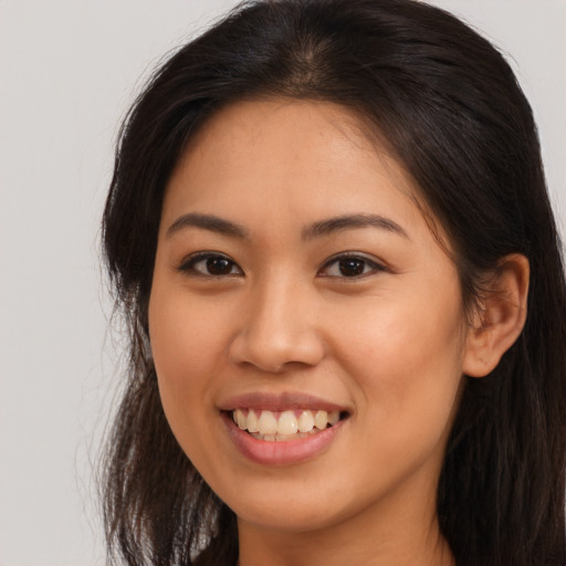 Joyful latino young-adult female with long  brown hair and brown eyes