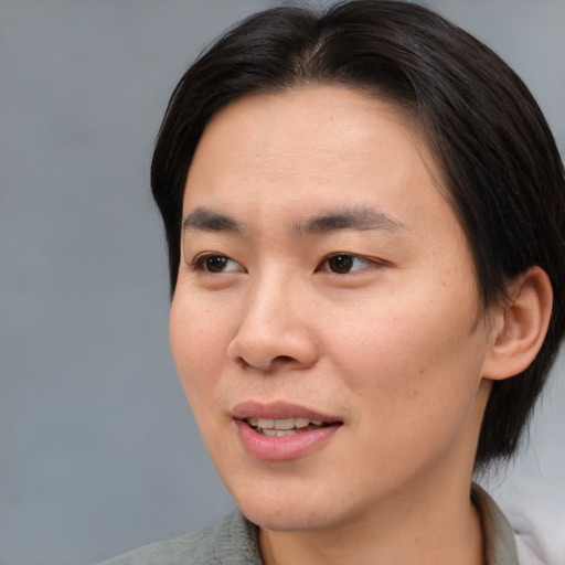 Joyful asian young-adult male with medium  brown hair and brown eyes