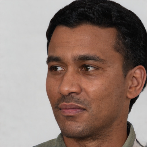 Joyful latino adult male with short  black hair and brown eyes