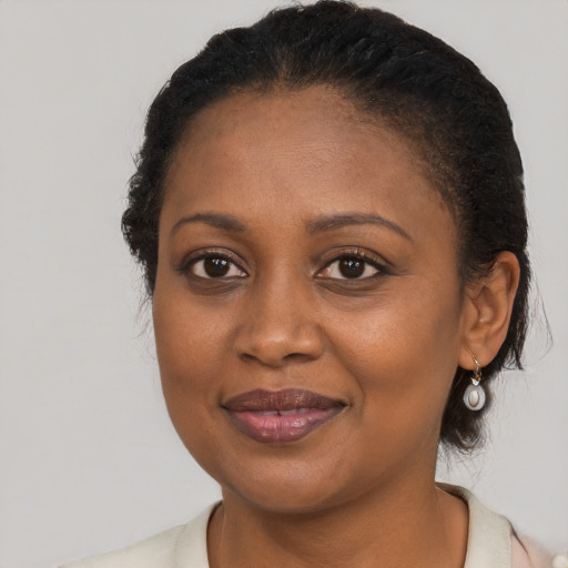 Joyful black young-adult female with long  brown hair and brown eyes