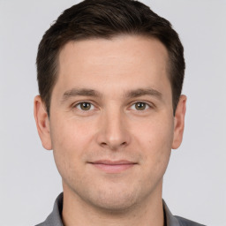 Joyful white young-adult male with short  brown hair and grey eyes