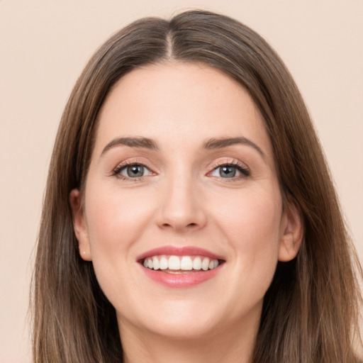 Joyful white young-adult female with long  brown hair and grey eyes