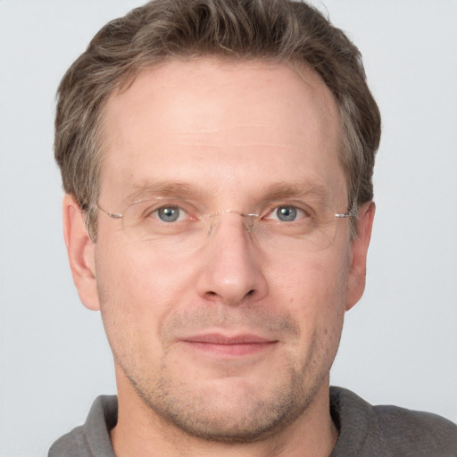 Joyful white adult male with short  brown hair and grey eyes