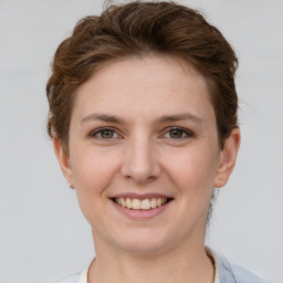 Joyful white young-adult female with short  brown hair and grey eyes