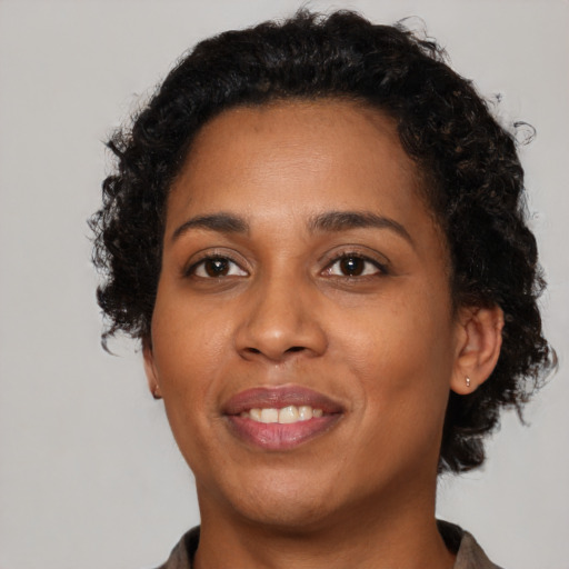Joyful black young-adult female with short  brown hair and brown eyes